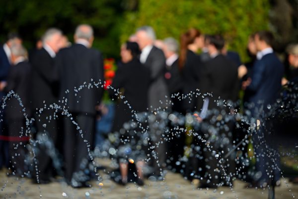 Blurred people in black suits on funeral